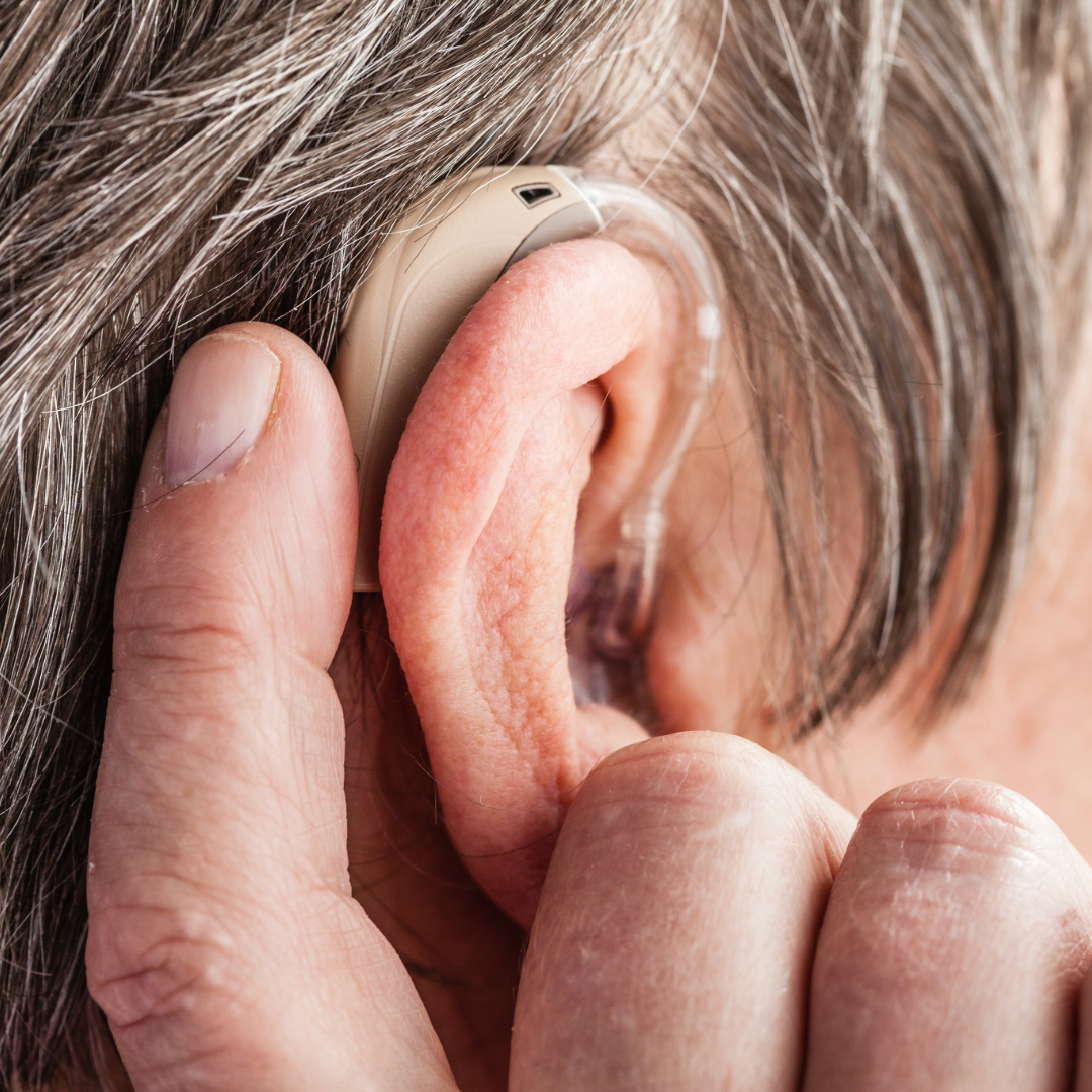 An elderly woman having a hearing aid fitted