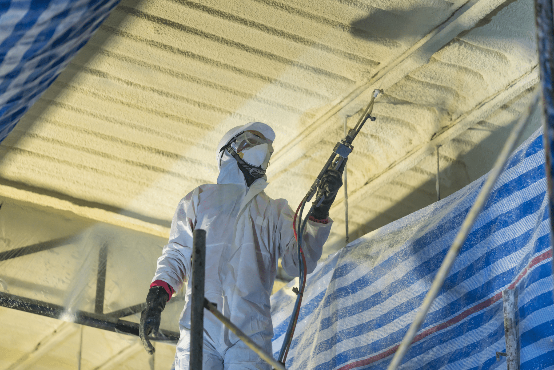 An installer applying spray foam insulation