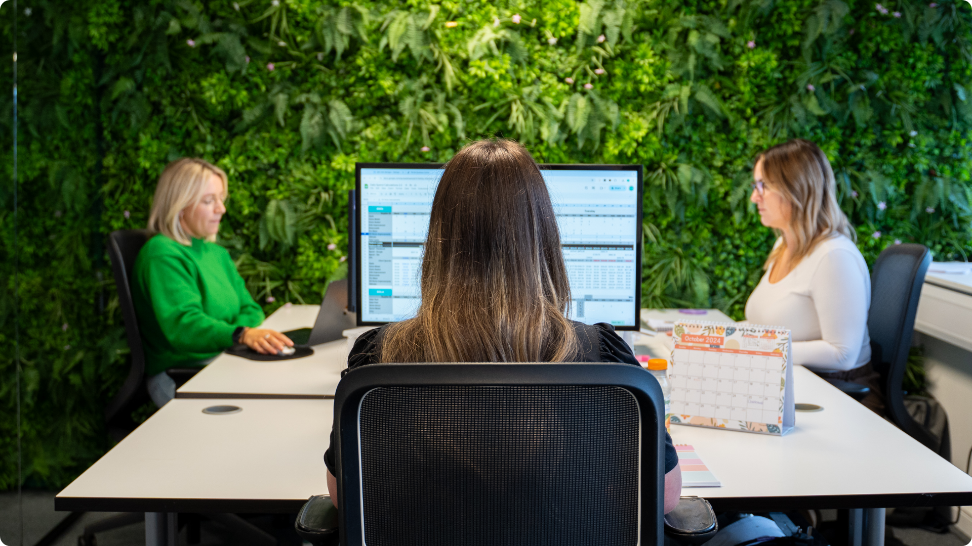 Specialists at work against the living wall in the Pronto office